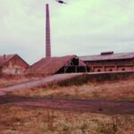 A gyár látképe a vasút felől. Bár a képen nem látszik, a rámpa mellett a hozzánk közelebbi oldalon ott a nagyvasúti iparvágány is