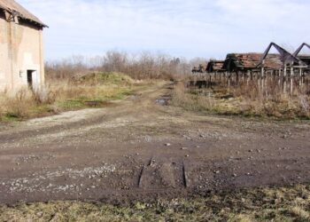 Útátjáró sínekkel a gyár területén. A szemben folytatódó földúton szépen sorban megvannak a betonaljak a földben